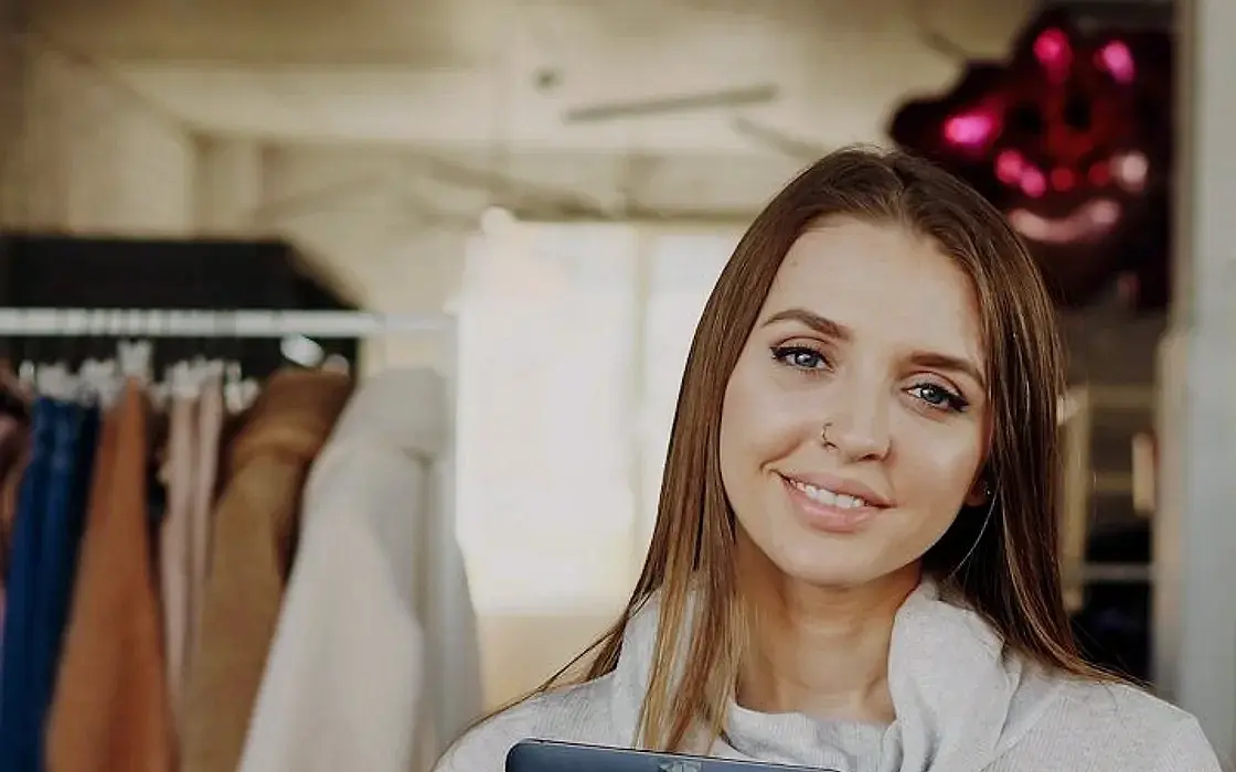 Boutique owner holding a tablet in her shop