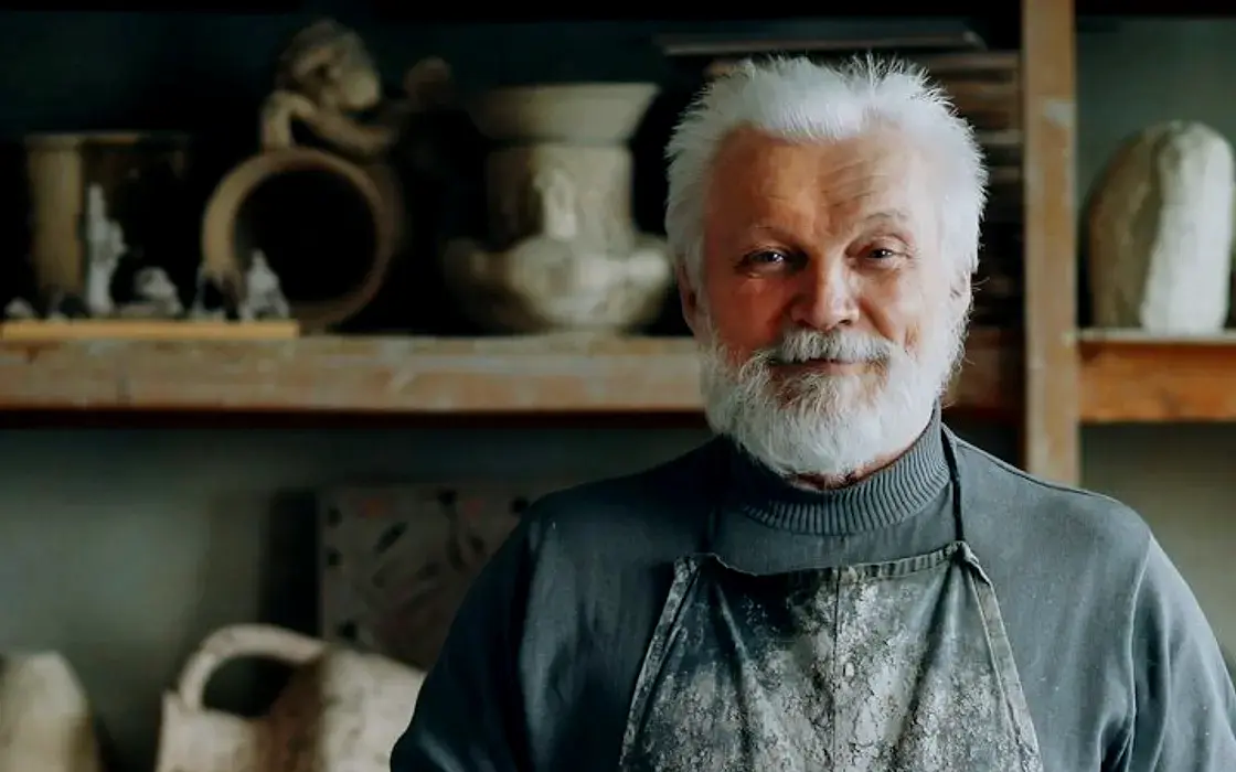 Potter with a white beard in his studio